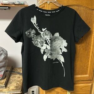 NWOT CALVIN KLEIN T SHIRT. NEW NEVER WORN. Beautiful floral pattern on front. ￼